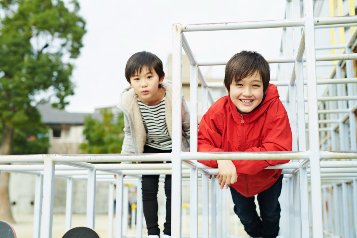 校庭の遊具で笑う男の子たち